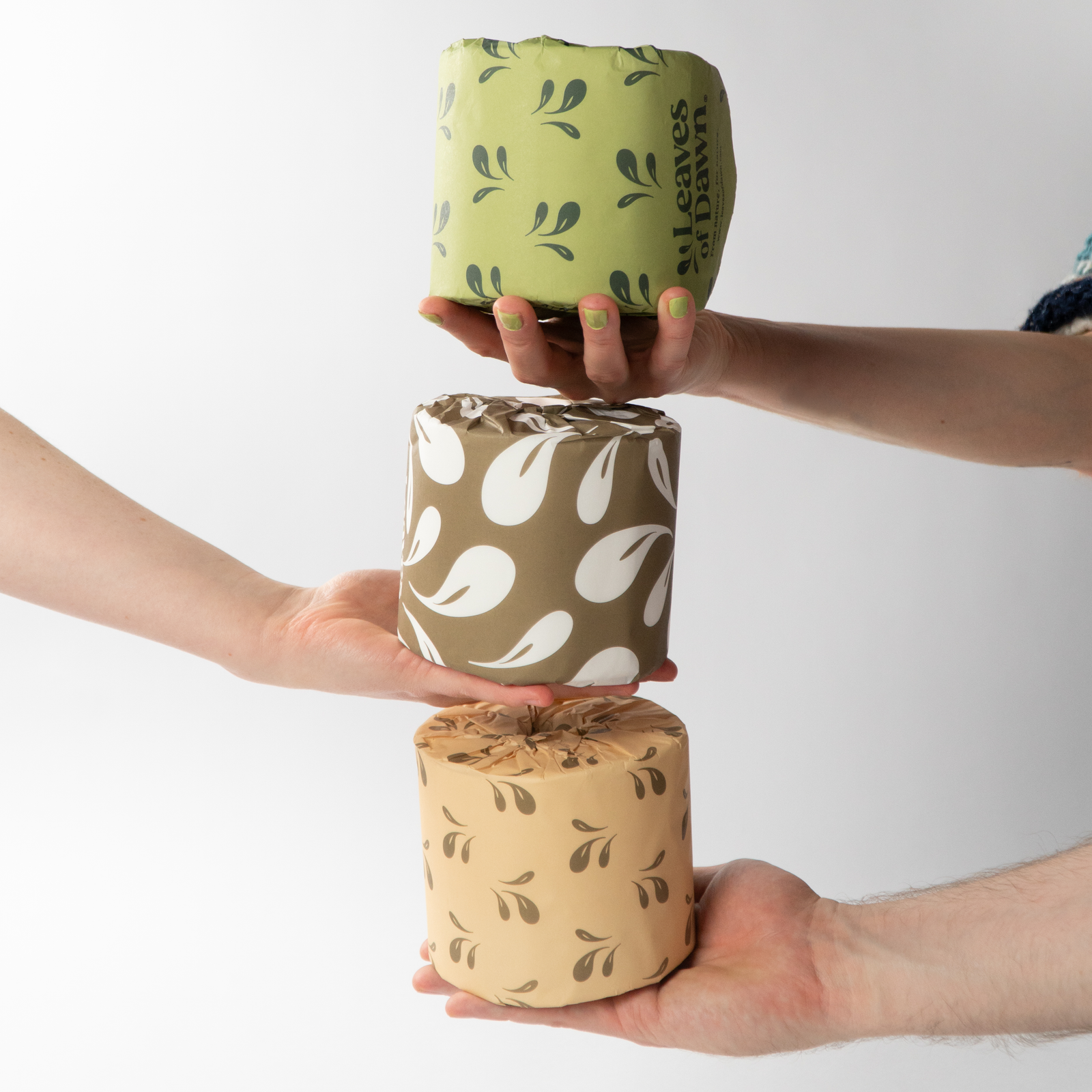 Leaves of Dawn premium 3-ply bamboo toilet paper rolls, hands holding the toilet paper rolls